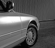 2000 Ford Crown Victoria - Side profile of a 2000 Ford Crown Victoria, showing the front fender and wheel.
