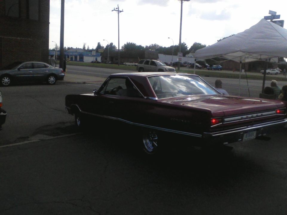 Maroon 1966 Dodge Charger coupe, rear 3/4 view, chrome wheels, parked outdoors