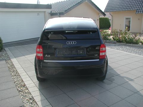 2001 Audi A4 - Black Audi A2 hatchback parked in front of a garage and house.