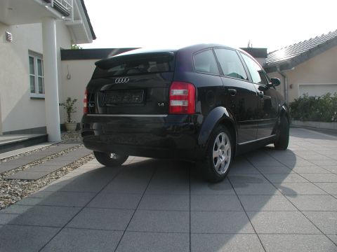 2001 Audi A4 - A black Audi A2 hatchback is parked on a paved driveway in front of a house.