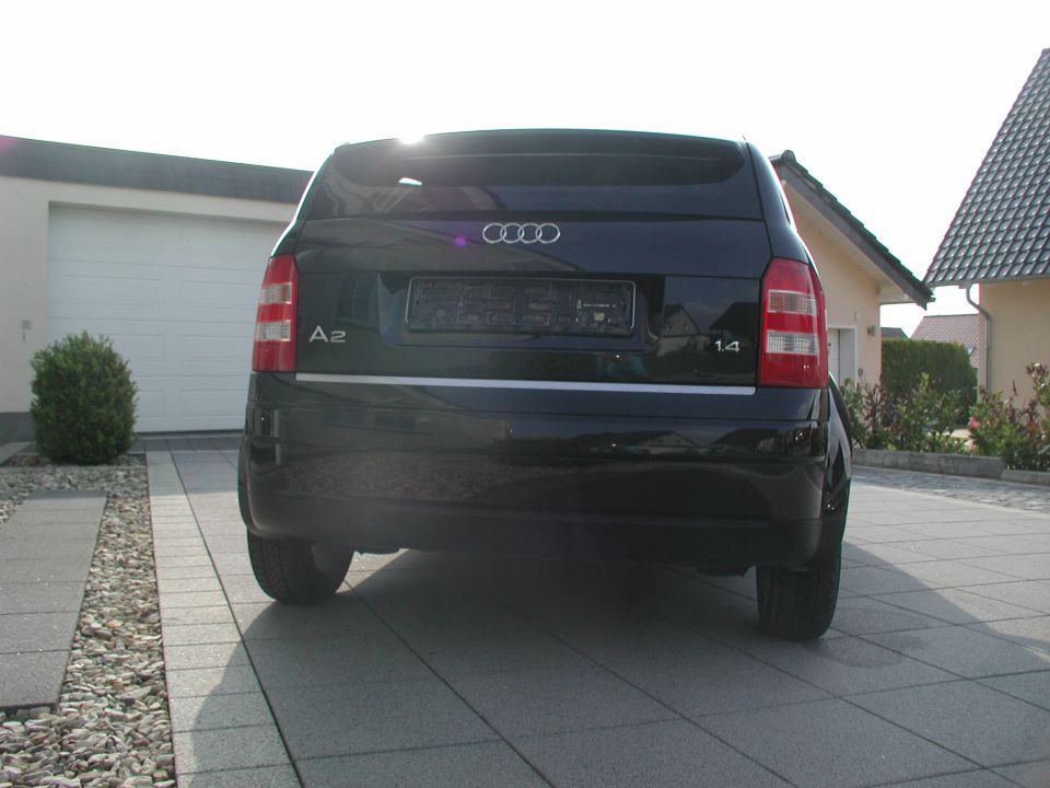 Black Audi A2 parked in driveway, rear view showing taillights and 'A2' badge