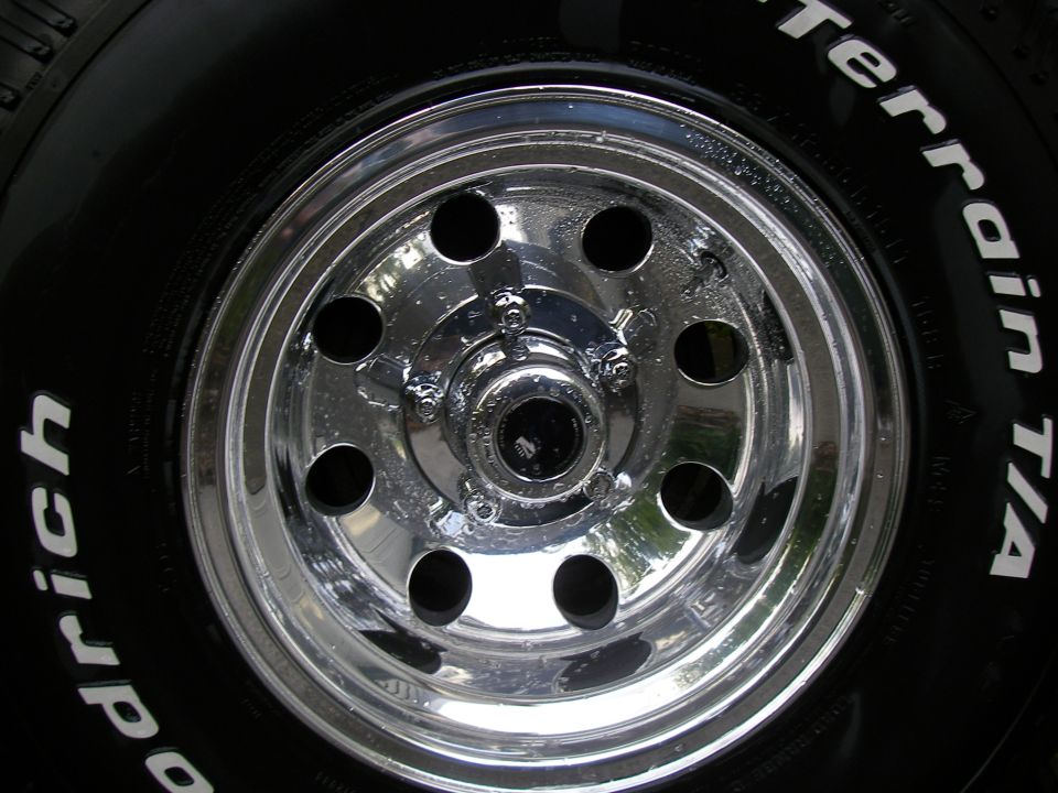 Chrome eight-slot wheel with BFGoodrich All-Terrain T/A white-letter tire, close-up