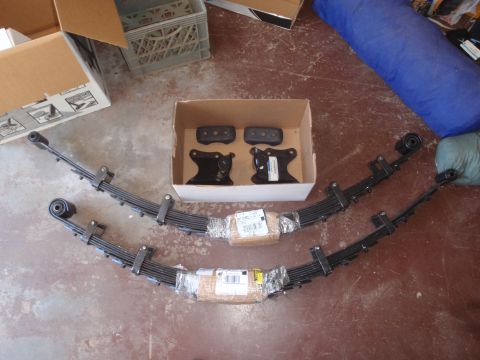 1994 Ford Bronco - New suspension parts are ready for installation, laid out on the floor with packaging and some boxes nearby.