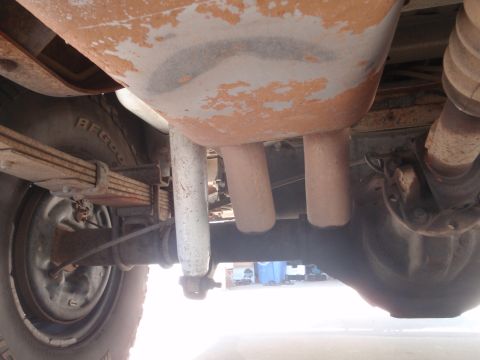 1994 Ford Bronco - The underside of a vehicle reveals its exhaust system, leaf springs, and rear axle components.