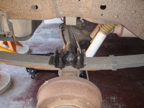 1994 Ford Bronco - Close-up view of the rear suspension and axle assembly, showing leaf springs and a shock absorber.