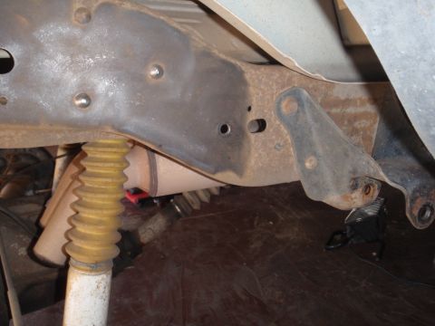 1994 Ford Bronco - Underside view of a vehicle's frame and suspension components, showing signs of rust and wear.