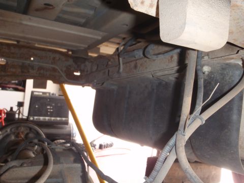 1994 Ford Bronco - The underside of a vehicle is shown, focusing on the fuel tank and suspension components.
