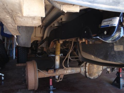 1994 Ford Bronco - Close-up view of the rear axle and suspension of a vehicle, with the year "1993" visible on the differential cover.