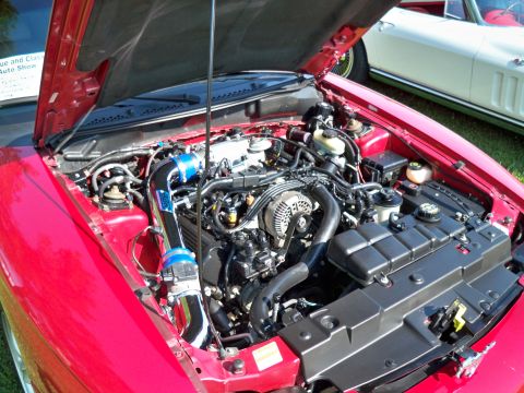 1998 Ford Mustang - The engine bay of a red 1998 Ford Mustang GT shows an aftermarket cold air intake system.