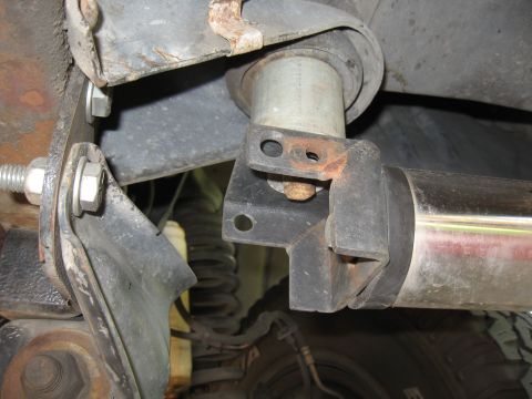 1994 Ford Bronco - Underside view of a vehicle's suspension and a nerf bar mounting bracket.