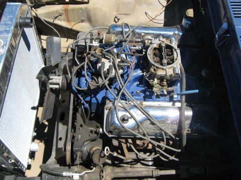 1978 Ford Bronco - The engine bay shows a V8 engine with blue paint and chrome accents, ready for installation or repair.