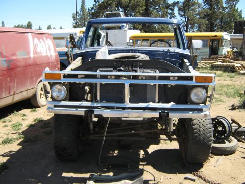 1978 Ford Bronco - This Ford truck is missing its hood and grille details, with a spare tire visible in the engine bay.