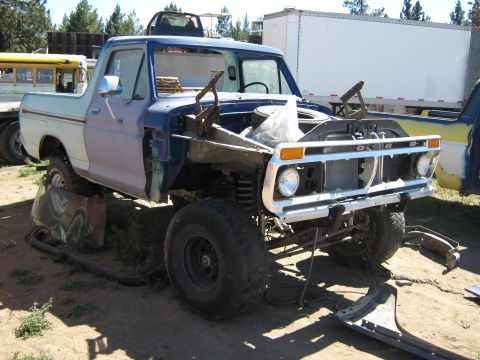 1978 Ford Bronco - This 1975 Ford pickup truck is missing its hood and has a disassembled front end, suggesting it is undergoing repairs or is being salvaged.