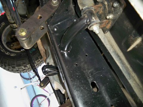 1985 Ford Bronco - Close-up of vehicle undercarriage, focusing on suspension and frame details.