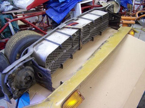 1972 Ford Mustang - Disassembled front-end components, including the grille and bumper, from a 1972 Ford Mustang.
