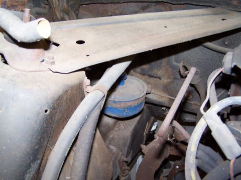 1972 Ford Mustang - Close-up view of engine bay components, including hoses and a blue-capped filter, showing signs of age and rust.