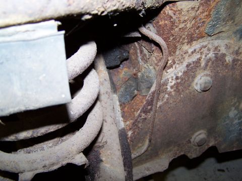 1972 Ford Mustang - Heavily rusted vehicle frame and suspension components are visible in this close-up shot.