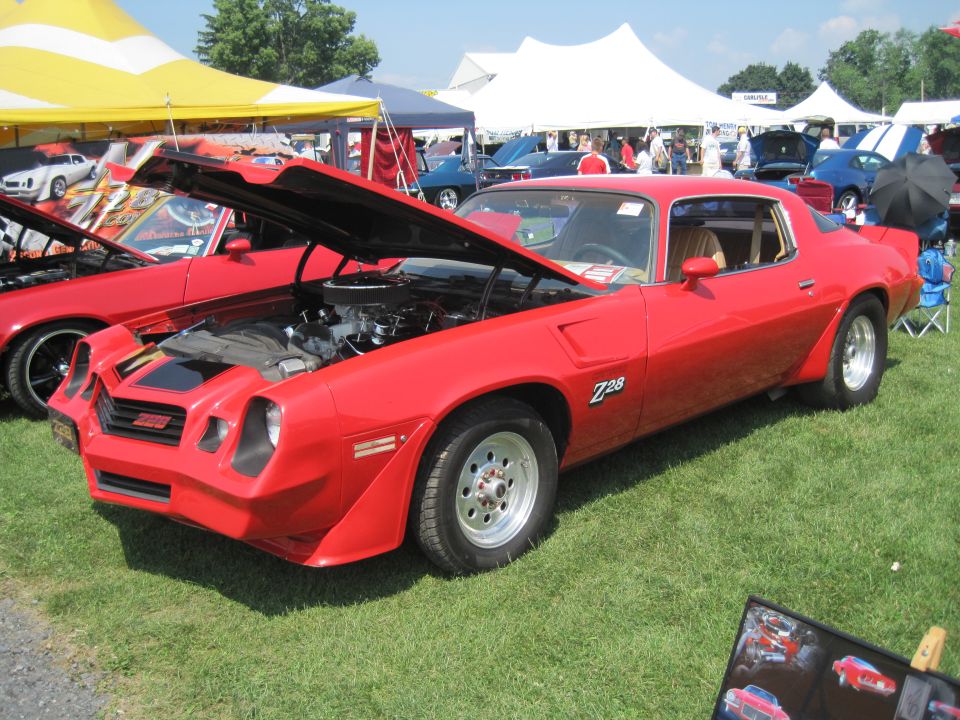 Red Z28 muscle car, front 3/4 view, hood open. Registry claims 2004 Aston Martin Virage