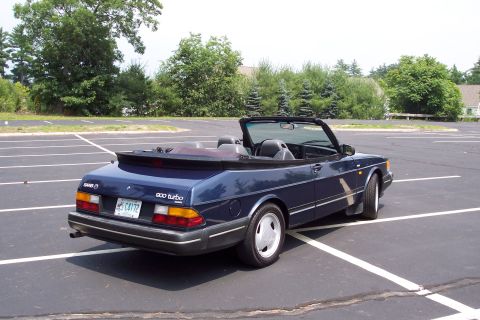 2001 Ford Crown Victoria - This blue Saab 900 Turbo convertible is seen from the rear passenger side in an empty parking lot.