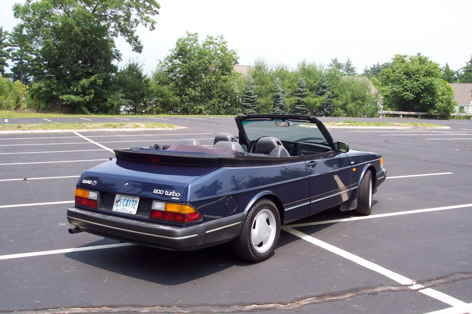 Blue Saab 900 Turbo convertible parked in a lot, rear passenger side view