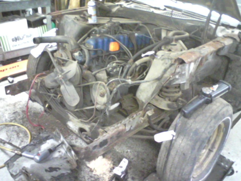 1972 Ford Mustang engine bay with engine removed, showing front suspension and frame