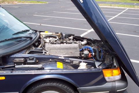 2001 Ford Crown Victoria - Engine bay of a dark blue Saab, hood raised, revealing the motor and surrounding components.