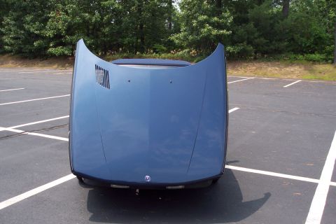 2001 Ford Crown Victoria - The hood of a blue car is open in a parking lot.