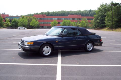 2001 Ford Crown Victoria - Dark blue Saab 900 convertible parked in a lot with a white car in the background.