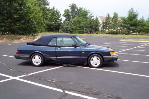 2001 Ford Crown Victoria - This blue Saab 900 Turbo Convertible is parked in an empty lot on a sunny day.