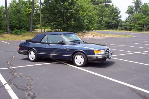 2001 Ford Crown Victoria - A blue 1992 Saab 900 convertible sits in a parking lot on a sunny day.