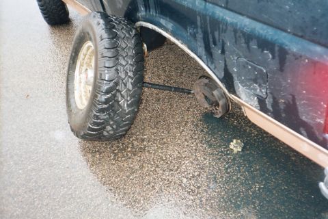 1994 Ford Bronco - The rear axle has broken off on this SUV, leaving the wheel detached.