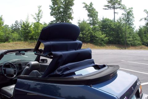 2001 Ford Crown Victoria - The complex mechanism of a deployed blue convertible soft top on a 1992 Saab 900 Turbo Convertible.
