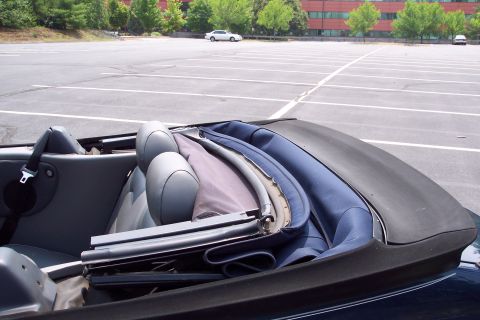 2001 Ford Crown Victoria - The interior of a convertible is shown with the top down, parked in an empty lot with a white car visible.