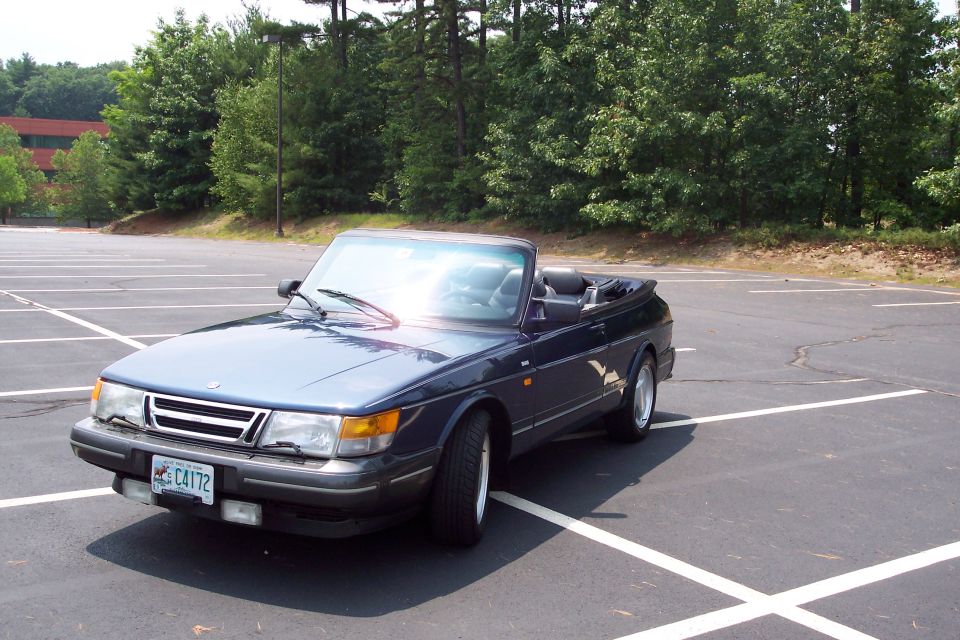 Dark blue convertible parked in an empty lot. License plate C4172
