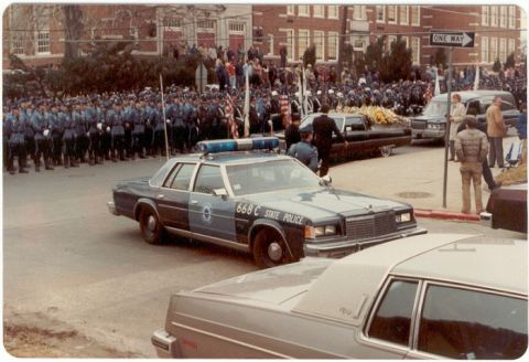 2001 Ford Crown Victoria - State Police car leads a funeral procession past a line of uniformed officers and onlookers.