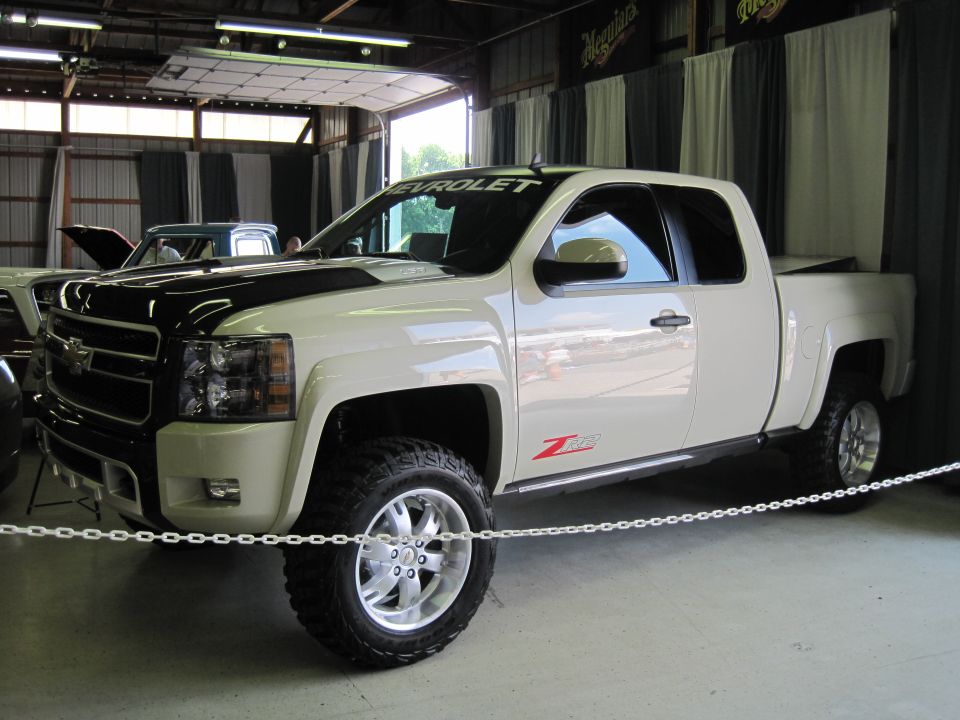 White Chevrolet pickup truck with black hood stripes and 'Z71' badging, seen from a 3/4 front angle