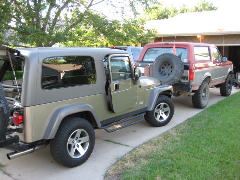 2005 Jeep Wrangler - A Jeep Wrangler and a Ford Bronco are parked side-by-side in a driveway.