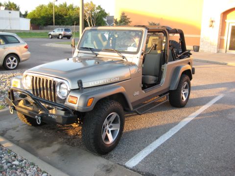 2005 Jeep Wrangler - A silver 2005 Jeep Wrangler Rubicon is parked in a lot with another vehicle visible in the background.