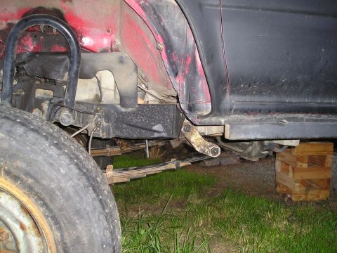 1990 Toyota Pickup/SR5 - Close-up view of the rear leaf spring suspension system on a vehicle, showing the mounting points and leaf springs.