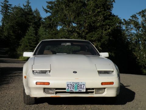 1989 Nissan 300ZX - A white 1989 Nissan 300ZX is parked on a gravel road with trees in the background.