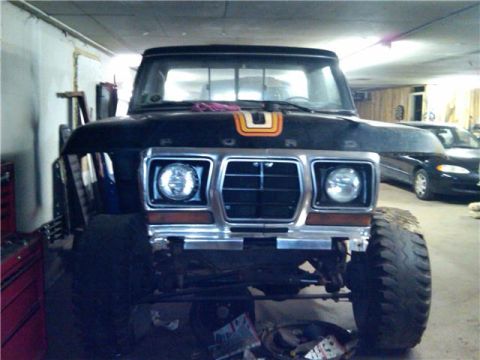 1979 Ford Bronco - Front view of a black 1978 Ford Bronco with a chrome grille and orange hood stripe.
