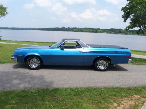 1973 Ford Ranchero - Blue 1973 Ford Ranchero with a black tonneau cover parked by a large body of water.