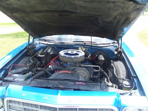 1973 Ford Ranchero - The engine bay of a blue 1973 Ford Ranchero, a prominent chrome air cleaner and V8 engine components.