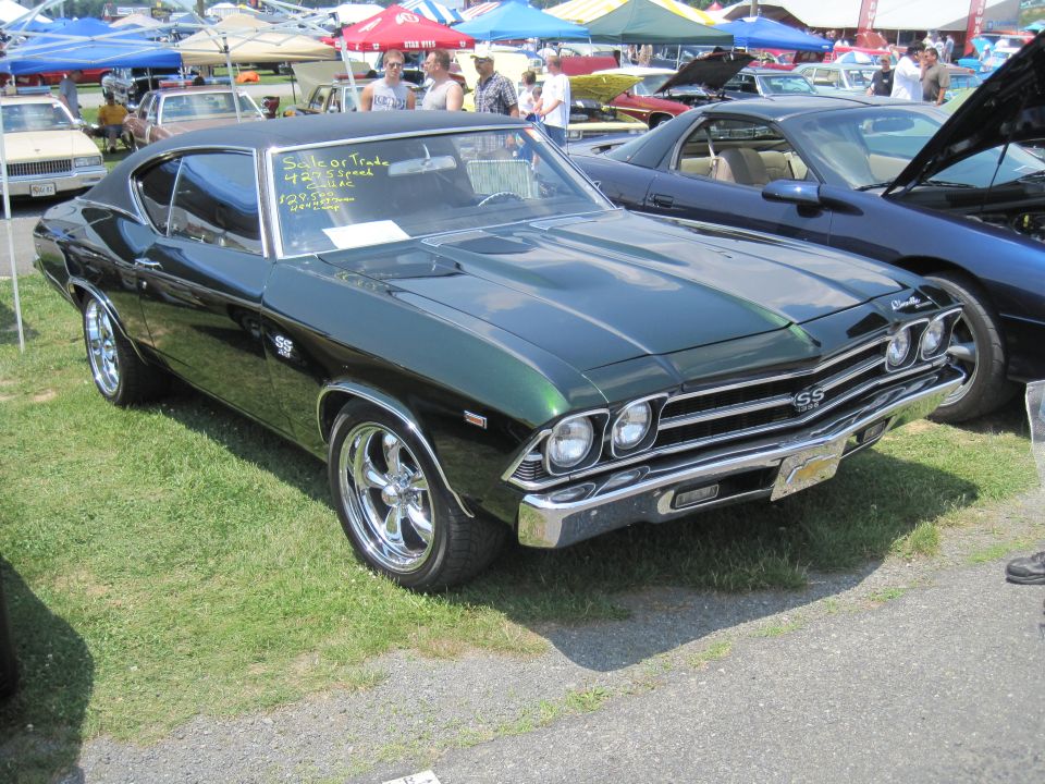 Green 1969 Chevrolet Chevelle SS with chrome wheels and a "Sale or Trade" sign on the windshield