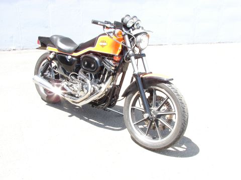 1993 Jeep YJ - A Harley-Davidson motorcycle with orange and black paint is shown from a three-quarter front perspective.
