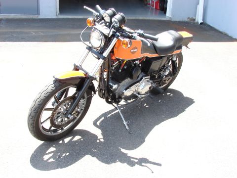 1993 Jeep YJ - A parked Harley-Davidson motorcycle with orange and black paint is shown from the front three-quarter view.