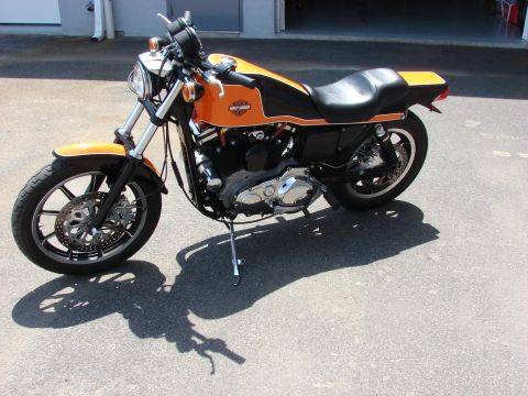 1993 Jeep YJ - A Harley-Davidson motorcycle with an orange and black paint scheme is shown from a three-quarter front view.
