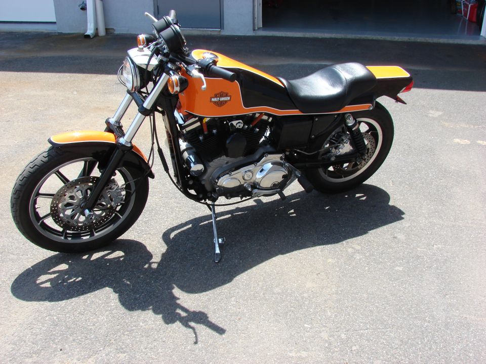 Orange and black Harley-Davidson motorcycle parked on pavement