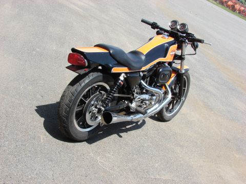 1993 Jeep YJ - A black and orange motorcycle is shown from the rear three-quarter angle on a paved surface.