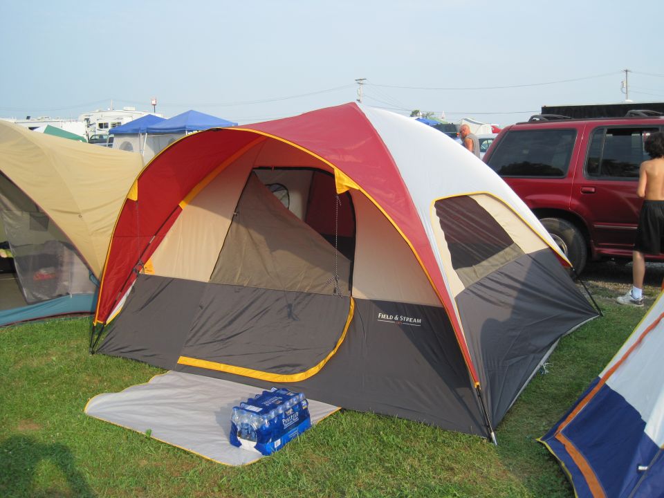 Red SUV parked next to camping tents
